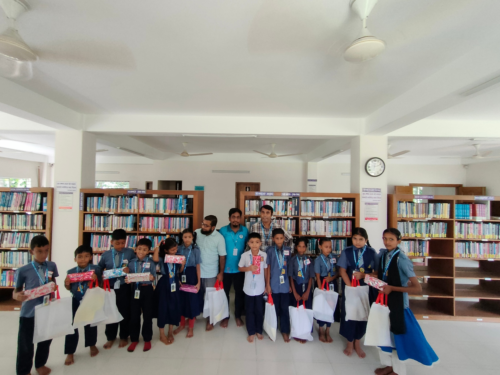 Reading Challenge prize ceremony — students with their awards inside the library.
